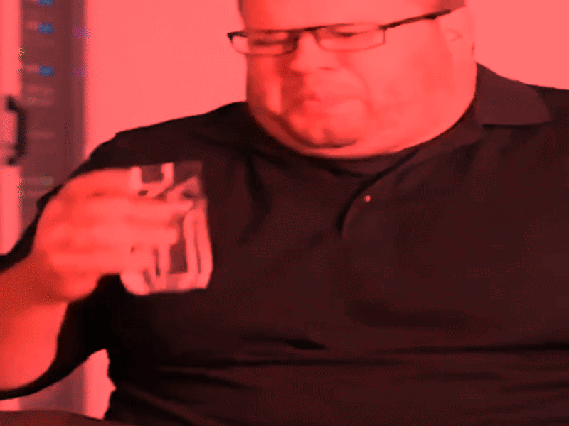 Coworker wearing glasses and holding a glass of water, under a red color effect